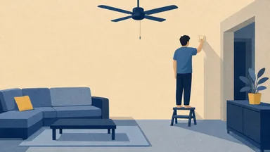 A ceiling fan with still blades and a person on a stool at the wall regulator