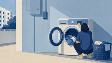 An open front-loading washing machine with wet laundry still inside the drum